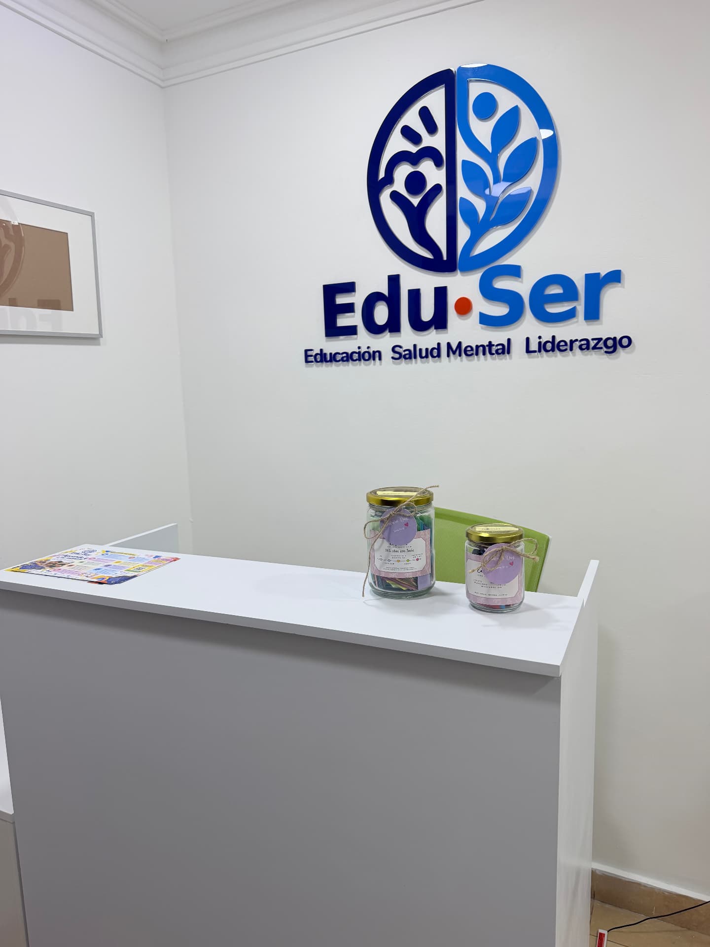 Fotografía real de la recepción de EDUSER con su logo en la pared