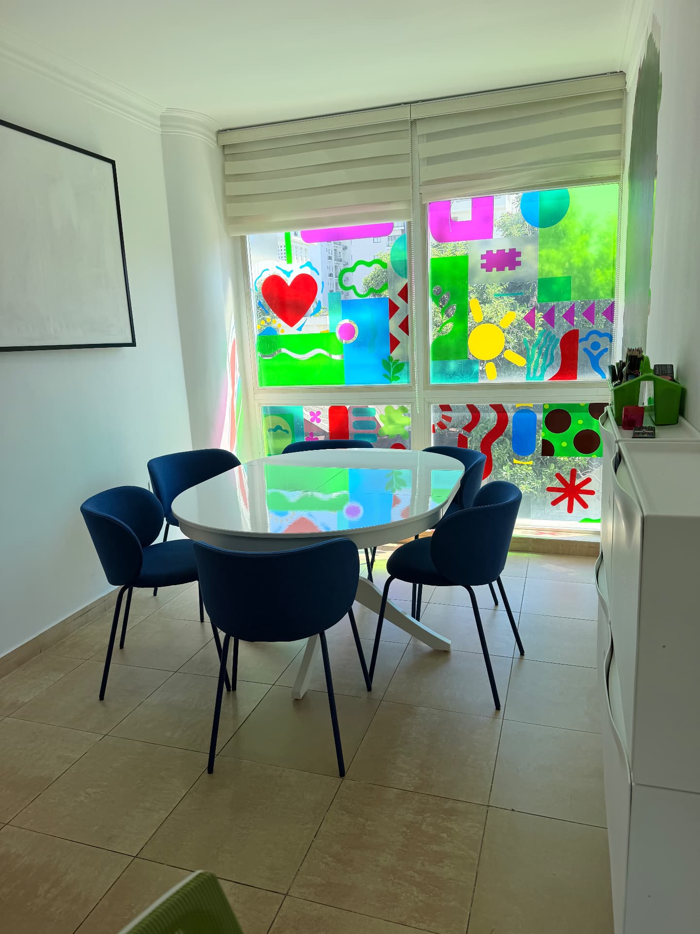 Fotografía real del aula de EDUSER con mesa ovalada y sillas azules